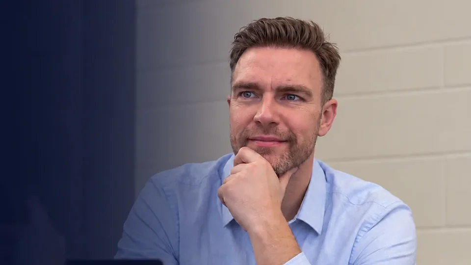 Richard listening closely, with his hand resting on his chin