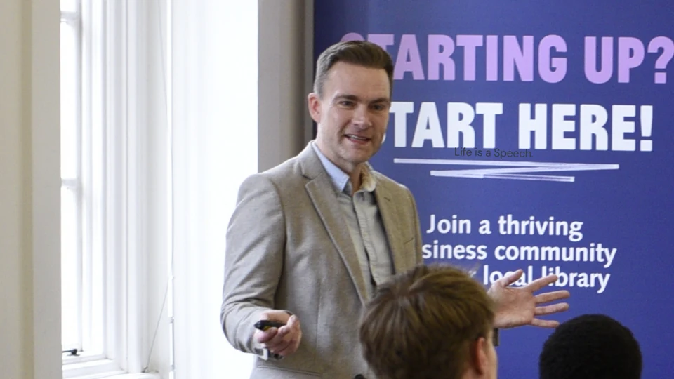 Richard presenting to a workshop group, gesturing towards the audience