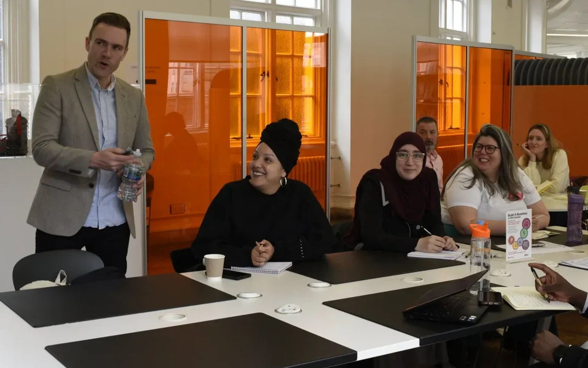 Richard talking with a workshop group seated around a table